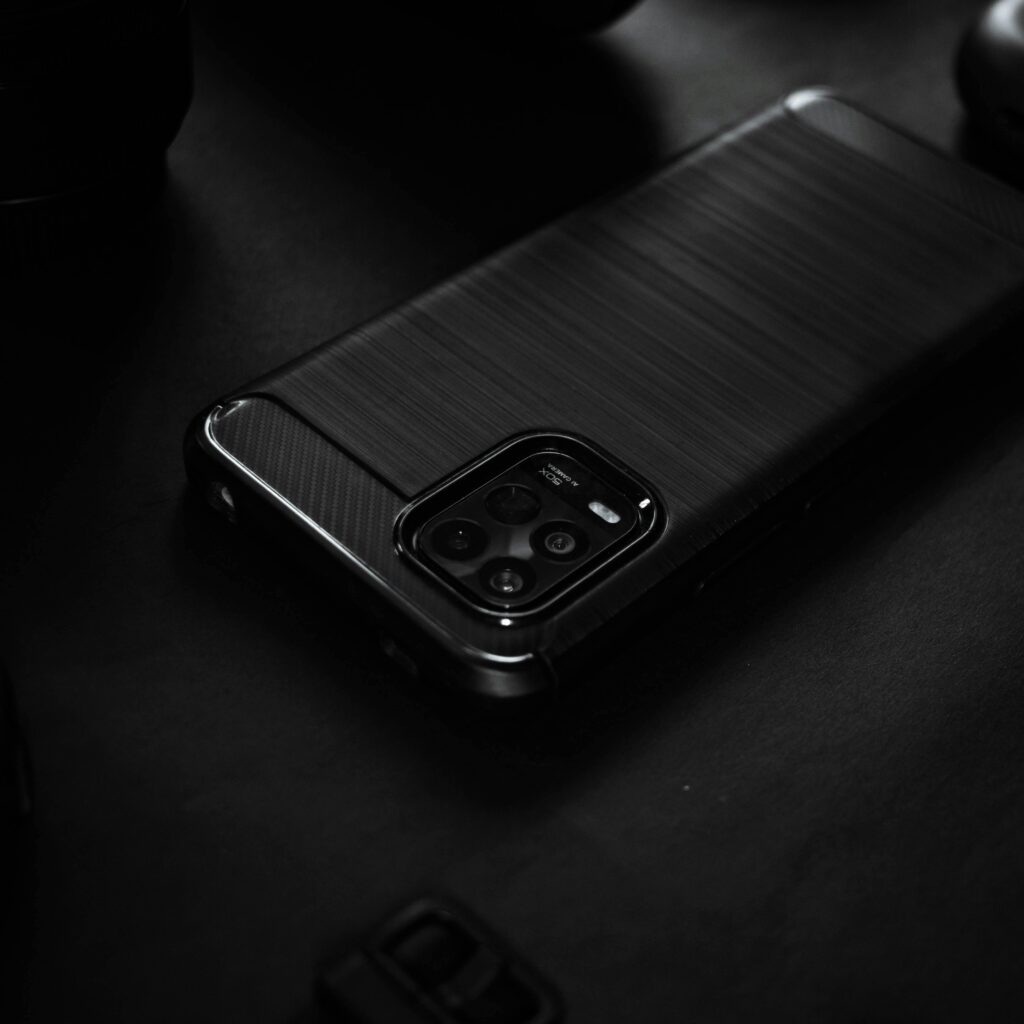 Close-up of a sleek black smartphone on a dark surface, highlighting elegant design.